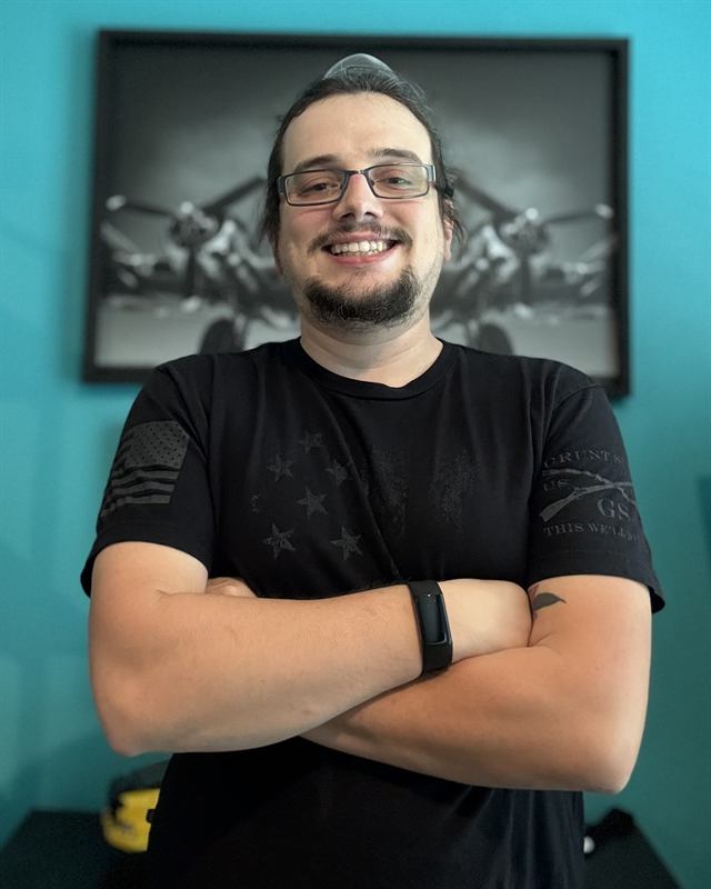 Anthony Tuccitto, smiling, arms crossed